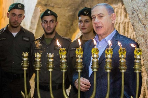 Israeli Prime Minister Benjamin Netanyahu attends a ceremony to mark the fifth night of Hanukkah at the Western Wall in the Old City of Jerusalem, on Dec. 20, 2014. Hanukkah, also known as the Festival of Lights and Feast of Dedication, is an eight-day Jewish holiday commemorating the rededication of the Holy Temple 