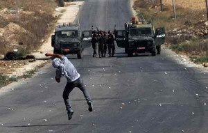 (140822) -- NABLUS, Aug. 22, 2014 (Xinhua) -- A Palestinian protester throws stones at Israeli soldiers during clashes following a demonstration against the Israeli offensive in the West Bank village of Beit Furik near Nablus on Friday, Aug. 22, 2014. A senior official of the United Nations Children's Fund (UNICEF) said here Thursday that a total of 469 children were killed in the Gaza Strip, where the situation is "dire" because of its debilitating effect on the 1 million Gaza Strip inhabitants under the age of 18. (Xinhua/Nidal Eshtayeh) (srb)