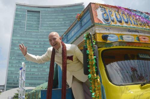 Jeff Bezos, Founder and CEO, Amazon.com with Amit Agarwal, Vice President and Country manager, Amazon.in atop a truck in Bangalore on Sept. 28, 2014. (Photo: IANS)
