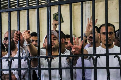 (140519) -- CAIRO, May 19, 2014 (Xinhua) -- Egyptian defendants react in a cage on a court of their trial over violence during 2013 Alexandria clashes in Sidi Gaber neighborhood, in Alexandria, coastal city of Egypt, on May 19, 2014. An Egyptian court sentenced on Monday an Islamic supporter of ousted president Mohamed Morsi to death, 18 others to life imprisonment and 10 over violence and murder charges in reaction to Morsi's removal last year, official MENA news agency reported. (Xinhua/Asmaa Abdelatif)(cy)