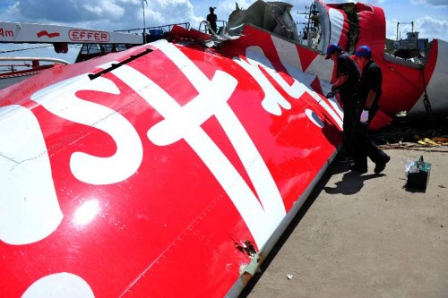 Members of Indonesia's National Transportation Safety Committee work on the tail of AirAsia Flight QZ8501 at Kumai port, Pangkalan Bun, Central Borneo, Indonesia, Jan. 12, 2015. After days of search, Indonesian navy divers have finally succeeded in retrieving the flight data recorder (FDR) of the crashed AirAsia Flight QZ8501 in the Java Sea, shedding light on determining the cause of the fatal crash with 162 people onboard.