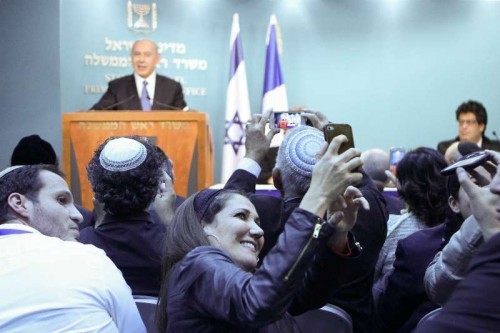 People take photos of a news conference addressed by Israeli Prime Minister Benjamin Netanyahu at the Prime Minister's office in Jerusalem, on Nov. 23, 2014. The Israeli cabinet on Sunday approved a controversial proposal which enshrines in law that Israel is the nation of the Jewish people amid growing tensions between Jews and Arabs.