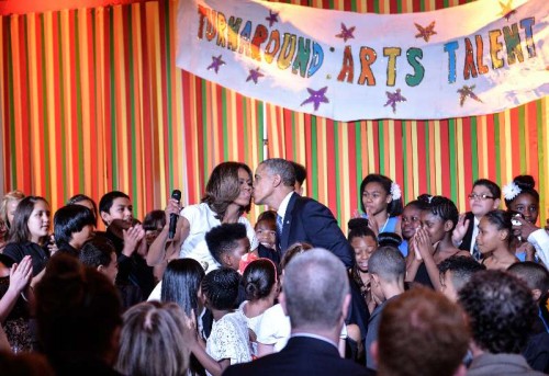 U.S. President Barack Obama and first lady Michelle Obama kiss at the Turnaround Arts Talent Show hosted by Michelle Obama and the President's Committee on the Arts and the Humanities (PCAH) at the White House in Washington D.C., capital of the United States, May 20, 2014. Turnaround Arts is a program to help turn around low-performing schools and increase student achievement through arts education. 