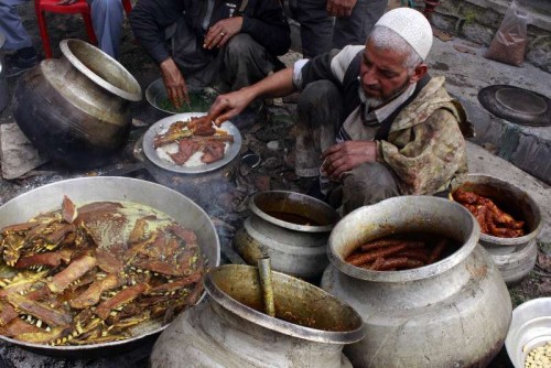 Kashmir: People busy cooking Wazwan - a Kashmiri cuisine that consists of thirty-six courses in Kashmir valley. The cuisine comprises of Maithi maaz, Rista (meatballs), Lahabi Kabab or Moachi Kabab (flattened mutton kababs cooked in yogurt), Waza Kokur (two halves or two full chicken cooked whole), Daeni Phoul ( a mutton dish), Doudha Ras (mutton cooked in sweet milk gravy), Rogan Josh (tender lamb cooked with Kashmiri spices),Tabak Maaz (ribs of lamb simmered in yogurt), Daniwal Korma (a mutton curry with coriander), Waza Palak (green spinach cooked with small pounced mutton balls known as Paliki Riste), Aab Gosh (lamb cooked in milk curry), Marchwangan Korma (an extremely spicy lamb preparation), Kabab, Gushtaba (meatballs in white yogurt gravy), Yakh'n (delicately spiced yogurt curry), Ruwangan Chhaman (cheese squares with Tomato gravy), Dum Aelva (potatoes cooked in yogurt gravy), Muji Chetintin (a radish and walnut chutney), Phirni (a milk pudding thickened with semolina or ground rice). (Photo: IANS)