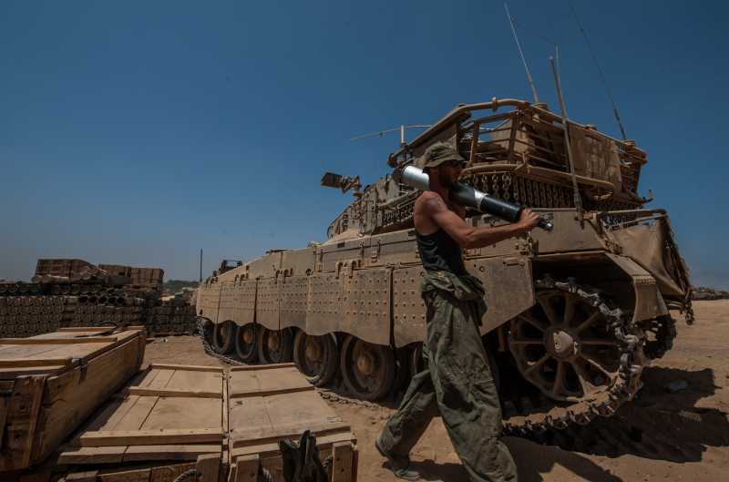 GAZA BORDER, July 31, 2014 (Xinhua) -- An Israeli soldier carries a shell at an army deployment area in southern Israel near the border with Gaza. Three Israeli soldiers were killed in the Gaza Strip on Wednesday, the Israel Defense Forces (IDF) spokesperson unit said in a statement.