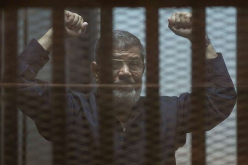 Egypt's ousted President Mohamed Morsi gestures behind the defendants' cage at a court in Cairo, Egypt, on June 16, 2015. An Egyptian court on Tuesday confirmed the death sentence against ousted President Mohamed Morsi over mass jailbreak during the 2011 political turmoil, state-run Nile TV reported. 