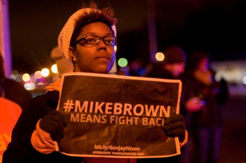  A woman takes part in a protest against the grand jury's decision not to charge police officer Darren Wilson in the fatal shooting of African American youth Michael Brown, in Ferguson, Missouri, the United States, Nov. 24, 2014. Violence erupted Monday night in Ferguson after the announcement that police officer Darren Wilson would not be indicted for shooting unarmed 18-year-old Michael Brown