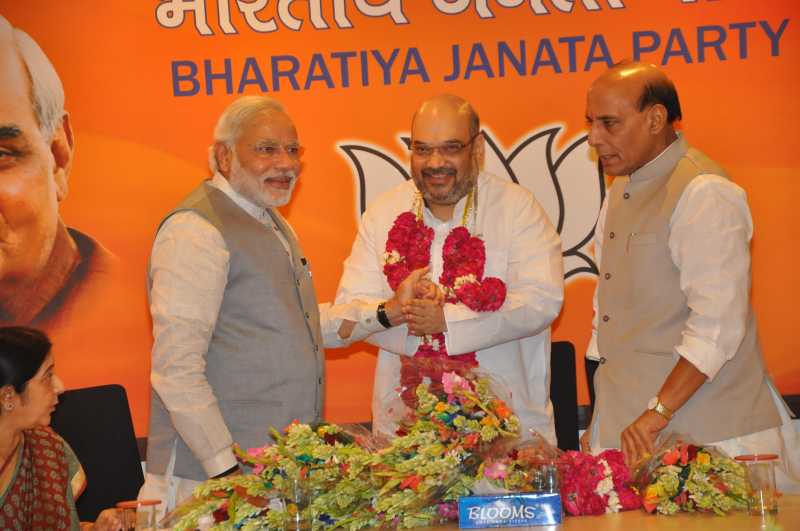 Prime Minister Modi congratulates Amit Shah as  Rajnath Singh looks on 