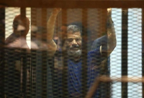 gypt's ousted President Mohamed Morsi waves hands in the defendants' cage on a court in Cairo, Egypt, on May 16, 2015. An Egyptian court sentenced Saturday ousted Islamist president Mohammed Morsi to death over 2011 jailbreak charges. 