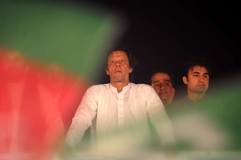  Imran Khan (L), head of opposition political party Pakistan Tehrik-e-Insaf, looks during an anti-government protest for the 12th day in Islamabad, capital of Pakistan . Pakistan's top court on Monday ordered the two opposition parties, of which thousands of activists protested against the government outside the parliament house, to vacate the main avenue as their sit-ins have affected the traffic in the capital. 