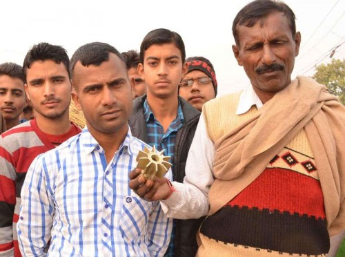 Villagers show a portion of a mortar allegedly fired from Pakistan at Keso-Kamoor village in Samba district of Jammu and Kashmir on Jan 5, 2015. 