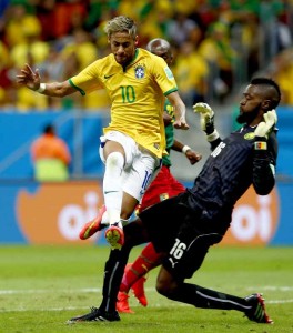 Brazil's Neymar (front) jumps over Cameroon's goalkeeper Charles Itandje during a Group A match between Cameroon and Brazil of 2014 FIFA World Cup at the Estadio Nacional Stadium in Brasilia, Brazil