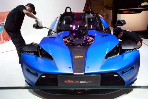 (140421) -- BEIJING, April 21, 2014 (Xinhua) -- A staff member checks a sports car during the media preview of the 2014 Beijing International Automotive Exhibition in Beijing, China, April 20, 2014. The auto show will be held on April 21-29, attracting over 2,000 exhibitors from 14 countries and regions. (Xinhua/Li Mingfang) (yxb)