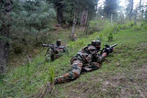 Soldiers take position during an encounter in Waderbala forests of Handwara, Jammu and Kashmir.