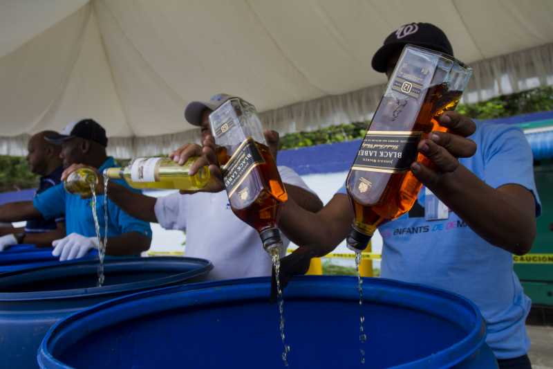 ANTO DOMINGO:  Employees of the Customs General Direction (DGA, for its acronym in Spanish), pour alcoholic beverages after being seized, in Santo Domingo, Dominican Republic. The DGA destroyed on Thursday 2000 boxes of whisky and alcoholic beverages, seized when being entered by contraband on national territory. The 2000 boxes, equivalent to 16,723.13 liters of different types of alcoholic beverages, with an approximate value of 11,793,331.76 dominican pesos, informed the engineer Fernando Fernandez, head of the DGA.