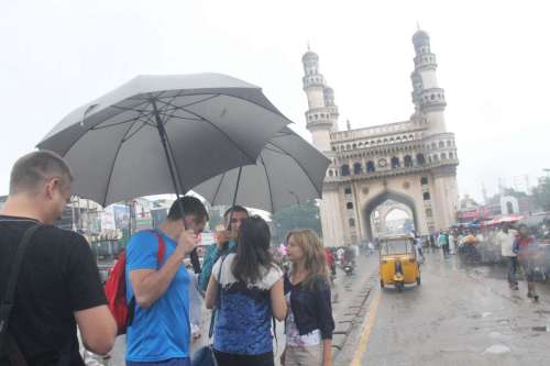 Foreign tourists enjoy themselves during rains at Charminar in Hyderabad 