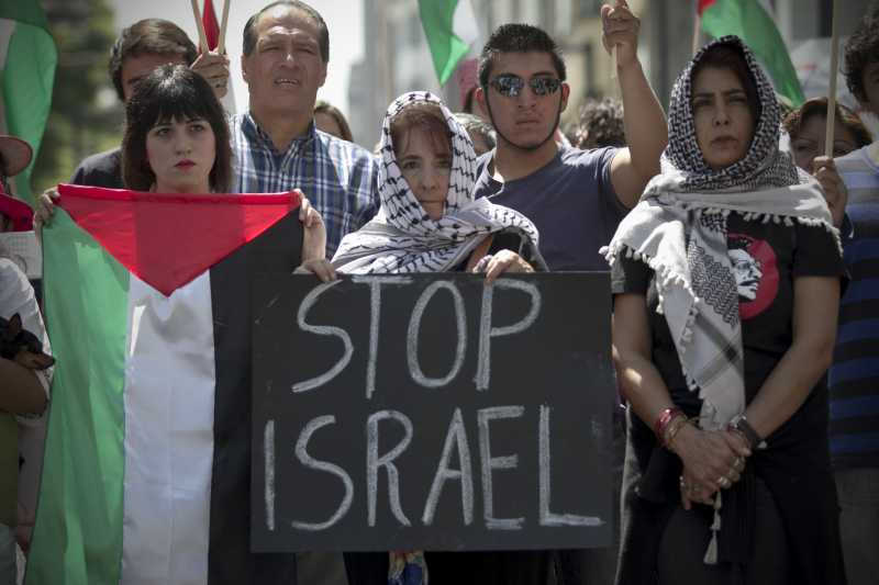 A woman holds a placard during a protest against Israeli's airstrikes on Gaza and in solidarity with the Palestinians, in Mexico City, capital