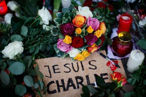 Flowers, candles, a pen and a poster saying "I am Charlie" are laid in front of the French Embassy in Berlin to commemorate the victims of the attack on French satirical weekly "Charlie Hebdo", in Berlin, Germany, on Jan. 9, 2015. Twelve people were killed on Wednesday in a shooting at the Paris office of Charlie Hebdo weekly. 