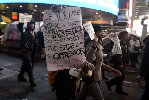 Protesters holding banners march at midtown Manhattan in New York, the United States, on Dec. 3, 2014, after a grand jury voted not to indict a white police officer in the chokehold death of a black man on Staten Island. Eric Garner, a 43-year-old father of six, died in July 17 after police officers attempted to arrest him for allegedly selling loose, untaxed cigarettes on Staten Island, New York.