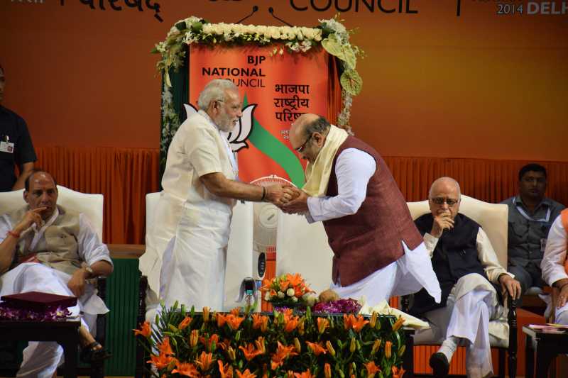 Prime Minister Narendra Modi congratulating newly appointed BJP President Amit Shah at the BJP National Council meeting in New Delhi on Aug. 9, 2014. (Photo: IANS)