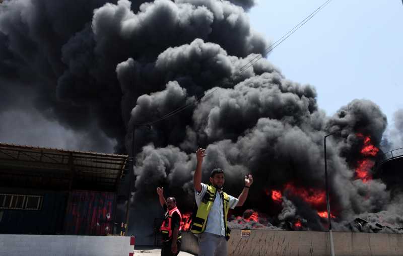 Palestinian firefighters react as flames engulf the fuel tanks of the main power plant which supplies electricity to the Gaza Strip, in Gaza City