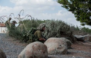 Israeli soldiers take position during an operation at an outpost in southern Israel near the border with Gaza