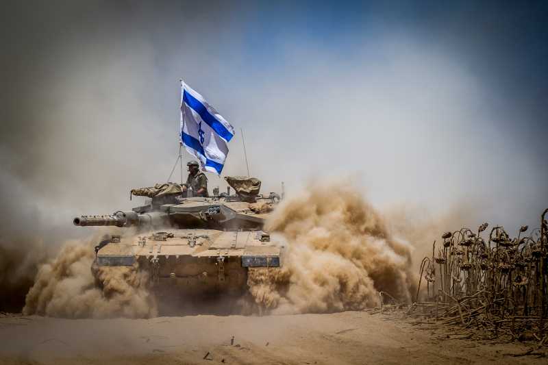  An Israeli Merkava tank pulls back from the Gaza Strip to an army deployment area in southern Israel bordering the Gaza Strip, on Aug. 3, 2014. The Israeli military has announced that it will hold fire for seven hours Monday in parts of the Gaza Strip to facilitate the entry of humanitarian aid and for displaced Palestinians to return to their homes. (Xinhua/JINI) (zhf)