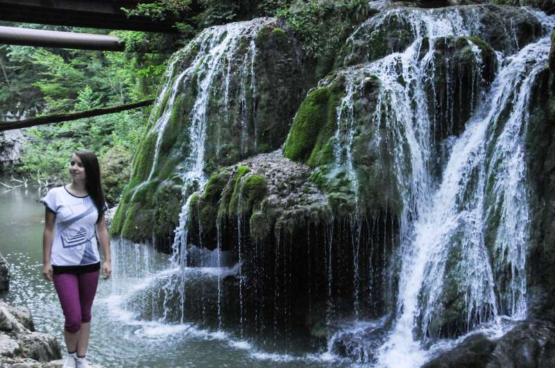 A tourist poses for photos in front of the Bigar Waterfall in Caras-Severin, southwestern Romania