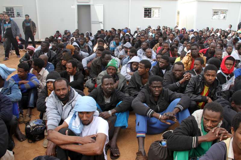  Dozens of illegal immigrants gather in a yard guarded by Libyan police in Misrata, Libya, on Feb. 18, 2015. Libya has long been a transit point for migrants seeking to reach Malta, Italy, and other places in Europe