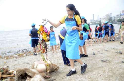 School students engaged in cleaning of the Girgaon Chaupati, a day after Ganapati immersions in Mumbai on Sept 9, 2014. (Photo: Sandeep Mahankal/IANS)