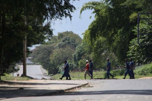  Burundian police walk towards the airport in Bujumbura, capital of Burundi, May 14, 2015. At least 15 workers including journalists and other agents Thursday got stranded inside Burundi National Radio and Television (RTNB) in an attack by pro-coup forces,