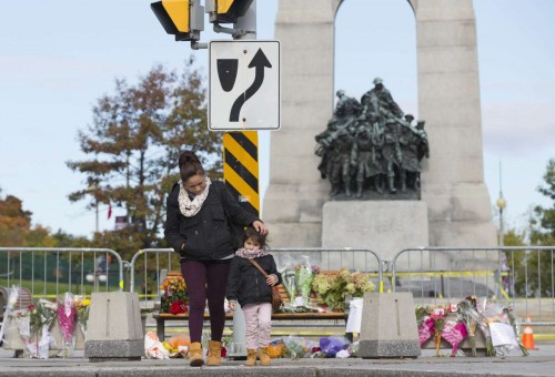 People pay their respect to fallen solider at the National War Memorial in Ottawa, Canada, Oct. 23, 2014. Canadian soldier Nathan Cirillo was fatally shot by a gunman at the National War Memorial one day ago. (Xinhua/Zou Zheng)