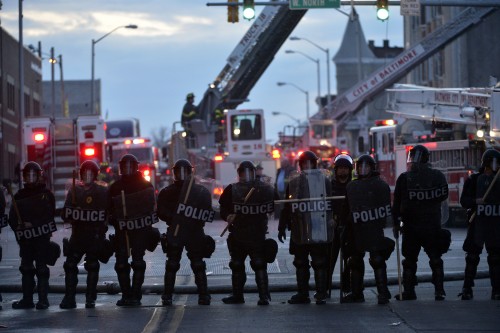 Policemen guard near a CVS pharmacy store which was set ablaze in Baltimore, Maryland, the United States, April 27, 2015. Maryland governor Larry Hogan Monday evening declared a state of emergency and activated the National Guard to address the escalating violence and unrest in Baltimore City following the funeral of a 25-year-old black man who died after he was injured in police custody. 