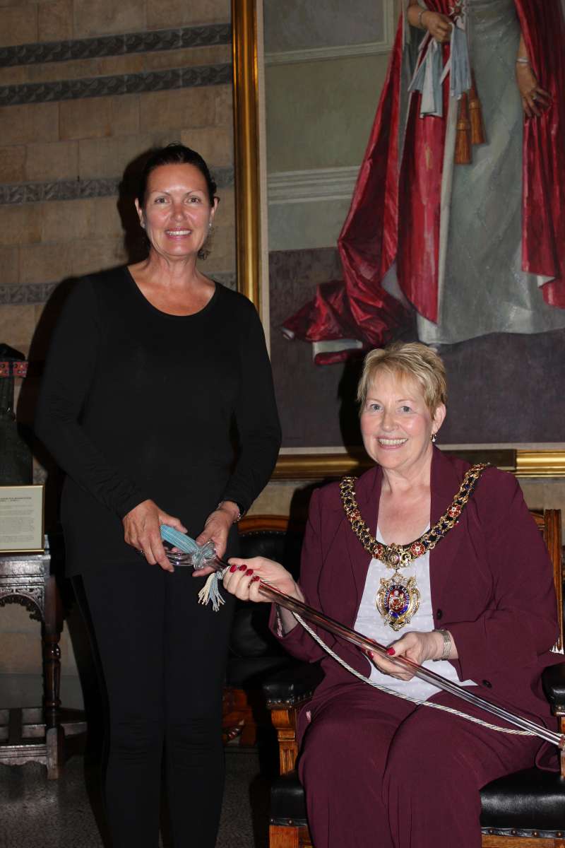 Janette Cox presents the Lord Mayor with a glass sword used at the opening of Manchester Town Hall in 1877