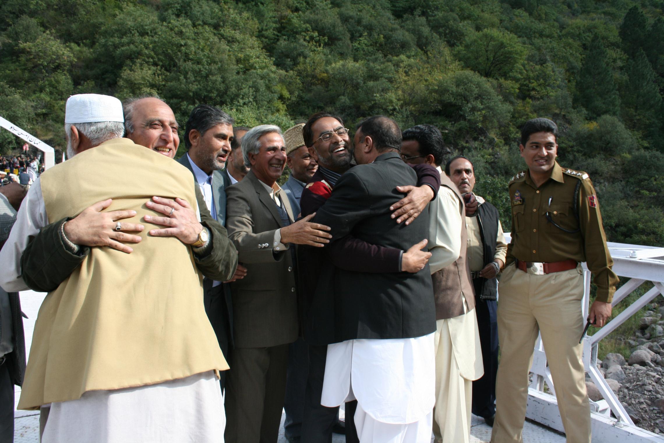 Political leaders and traders from Azad Jammu and Kashmir (Pakistani side and Jammu and Kashmir (Indian side) hug on the Chakoti Bridge after 60 years of separation
