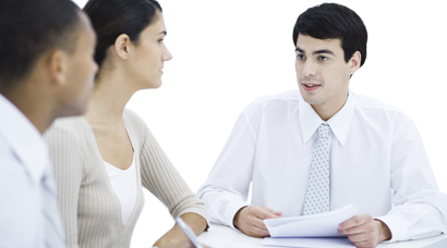 Professionals sitting at table, discussing documents