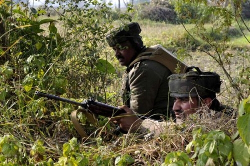 Soldiers take position during an encounter with militants who launched an attack on an army camp in Samba district of Jammu and Kashmir on March 21, 2015.