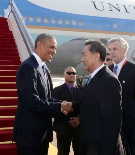 U.S. President Barack Obama  is welcomed by Chinese Foreign Minister Wang Yi upon his arrival in Beijing, China, Nov. 10, 2014. Obama is in Beijing to attend the 22nd Asia-Pacific Economic Cooperation (APEC) Economic Leaders' Meeting and pay a state visit to China. 