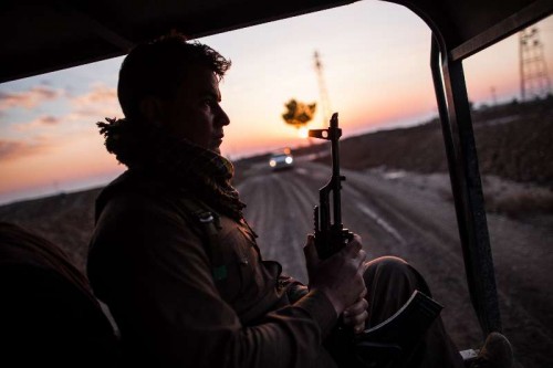 A Kurdish fighter sits in a vehicle heading to the front line with so-called Islamic State in southwest suburb of Kirkuk in the northern Iraq, Dec. 10, 2014. 