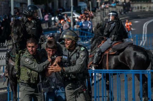  A Palestinian demonstrator is detained by Israeli policeman near Damascus Gate in the Old City of Jerusalem, on May 17, 2015. Tens of thousands of Jews marched Sunday through east Jerusalem's Muslim Quarter, sparking scuffles between Palestinians and the police. The controversial march celebrated Israel's 48th Jerusalem Day, marking the "reunification" of the city after Israel seized the Arab eastern part of the city during the 1967 Mideast War