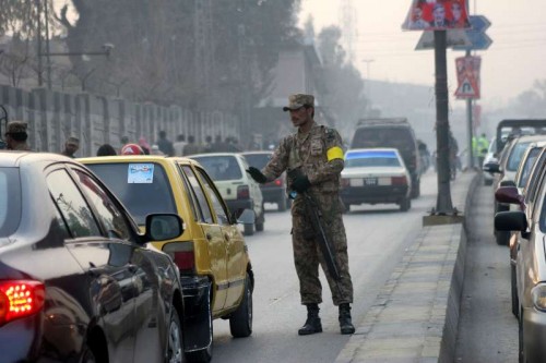  A Pakistani soldier stops vehicles near the Army Public School in northwest Pakistan's Peshawar, Jan. 12, 2015. Schools in Pakistan's northwestern city of Peshawar reopened on Monday for the first time since a Taliban raid massacred 150 people, mainly children, with returning students expressing defiance tinged with apprehension. 