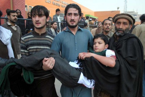 Volunteers hold an injured boy at a hospital in northwest Pakistan's Peshawar, Dec. 16, 2014. 