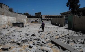 A Palestinian inspects the damage at Ali ibn Abi Taleb government school that was targeted overnight by Israeli airstrikes in Gaza City, on August 26, 2014. A ceasefire came into effect on Tuesday at 7:00 a.m. (0400 GMT), after an agreement, brokered by Egypt, reached between Israel and the Palestinian factions, including Hamas movement.  FILE PHOTO