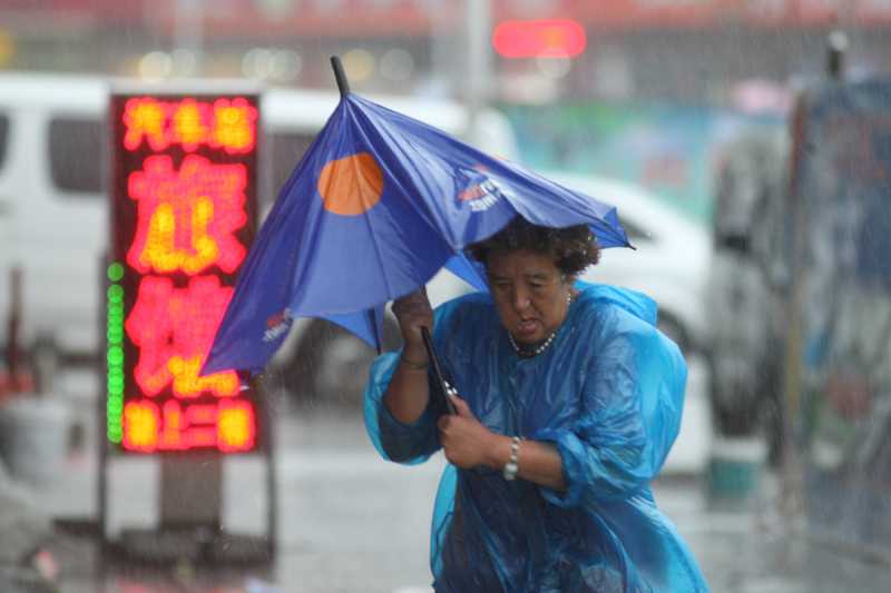  A woman walks in rainstorm in Yantai City