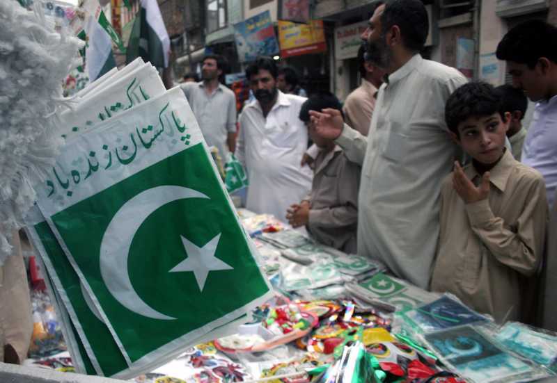 PESHAWAR: Pakistani people shop at a stall on the eve of Pakistan's 68th Independence Day in Peshawar, northwest Pakistan, on Aug. 13, 2014. (Xinhua/Ahmad Sidique)(srb)