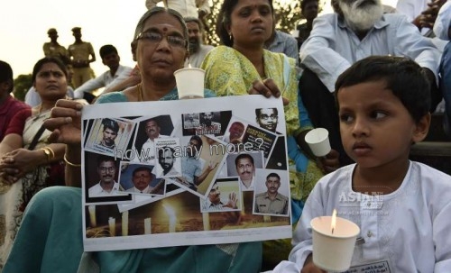 A child participates in a candlelight vigil to condemn the mysterious death of Bangalore Additional Commissioner of Commercial Taxes D K Ravi