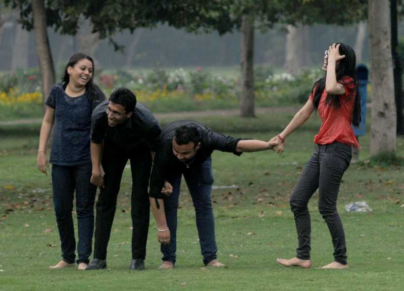 People enjoy themselves after rains at India Gate lawns in New Delhi on March 28, 2014. (Photo: IANS)