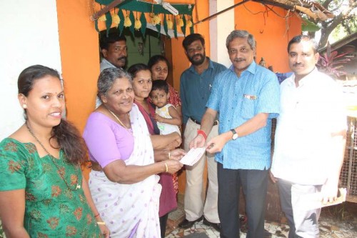  Union Defence Minister Manohar Parrikar hands over BJP membership card to a family in Ribandar, Goa.FILE PHOTO