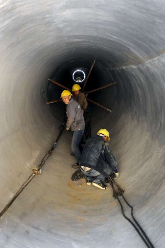 Workers lay pipes in the construciton of the South-to-North Water Diversion project in Zhengzhou, capital of central China's Henan Province, Nov. 14, 2014. About 911 kilometers of water pipes or 94.2 percent of the total lenght for the South-to-North Water Diversion project in Henan Province have been laid. The future two months will see the operation of 18 water plants, which are designed to receive the water pumped by the South-to-North Water Diversion project. With an estimated investment of 500 billion yuan (81 billion U.S. dollars), the south-to-north water diversion project has east, middle and west routes, transferring water to north China from the lower, middle and upper reaches of the Yangtze River, the longest in the country.