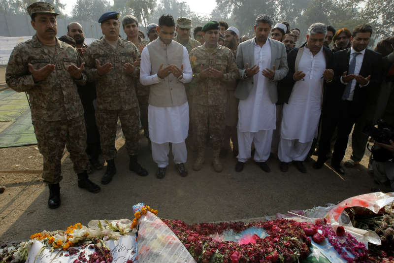 British boxer Amir Khan (3rd L, front) prays with Pakistani military officials at a memorial in the army-run school where 150 people were massacred by the Taliban in northwest Pakistan's Peshawar. 